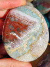 Load image into Gallery viewer, hand holding ocean jasper palm stone for meditation

