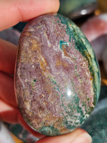hand holding ocean jasper palm stone for meditation